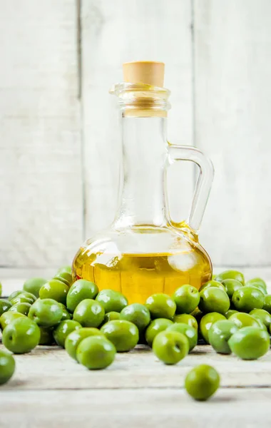 Olivový olej v průhledné láhvi na dřevěné pozadí. Selektivní fokus. — Stock fotografie