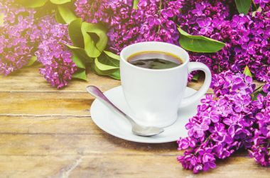 Kahve kahvaltı ve eflatun çiçekler. Seçici odak. 