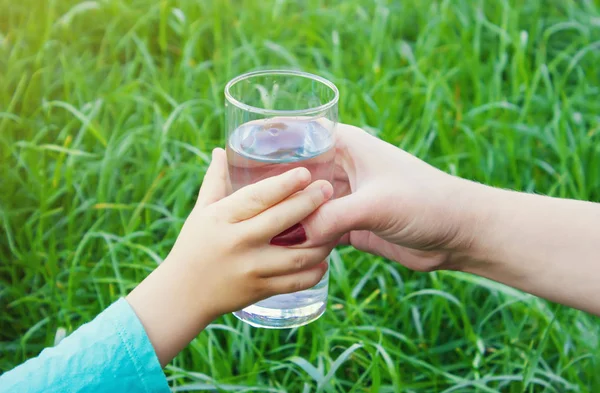 Жінка дає дитині склянку чистої води. Вибірковий фокус . — стокове фото