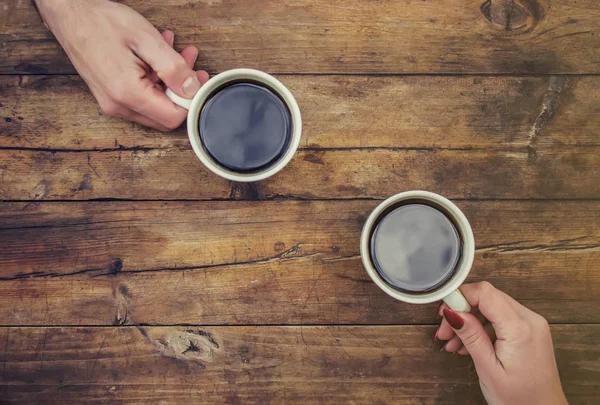 Coffee in hand. The lovers are together. Selective focus.