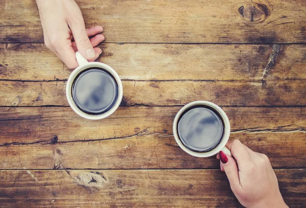 Coffee in hand. The lovers are together. Selective focus.