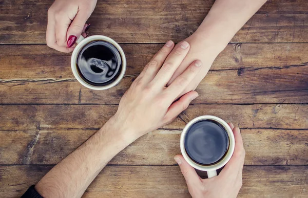 Coffee in hand. The lovers are together. Selective focus.