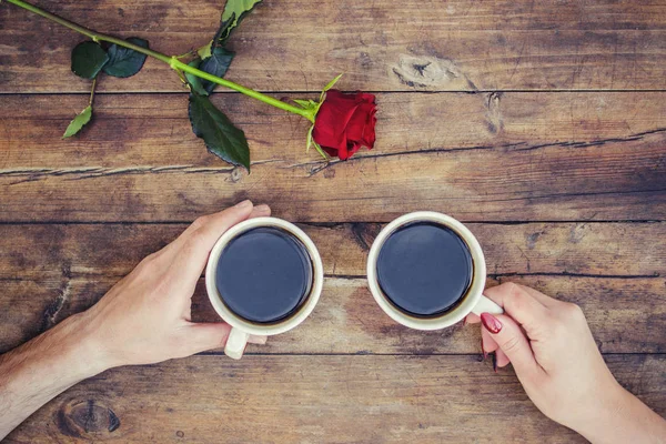 Coffee in hand. The lovers are together. Selective focus.