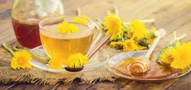 Dandelion bal ve bir bardak çay. Seçici odak.