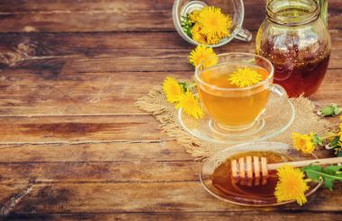 Dandelion bal ve bir bardak çay. Seçici odak.