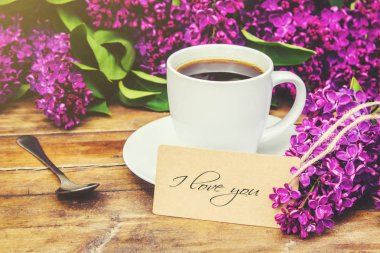 Kahve kahvaltı ve eflatun çiçekler. Seçici odak. 