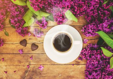 Kahve kahvaltı ve eflatun çiçekler. Seçici odak. 