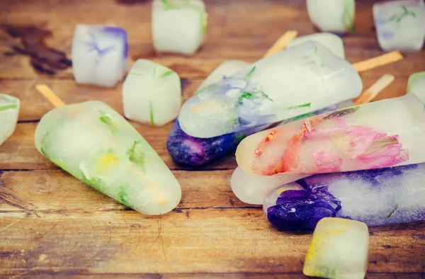 buz küpleri ve dondurma bir çubuk üzerinde donmuş çiçeklenir. seçici odak.