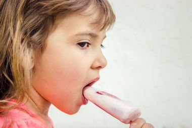 Çocuk dondurmalı çilek yiyor. Seçici odak.