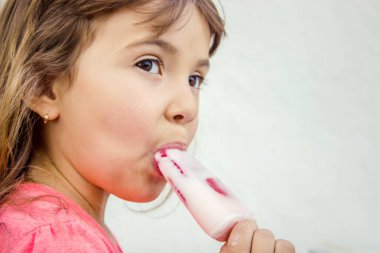 Çocuk dondurmalı çilek yiyor. Seçici odak.