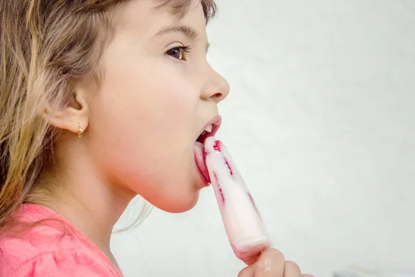 Das Kind isst Eis mit Erdbeeren. Selektiver Fokus. — Stockfoto