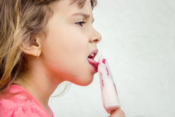 Das Kind isst Eis mit Erdbeeren. Selektiver Fokus. — Stockfoto