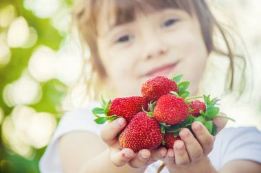 Çocuk ve çilek. Seçici odak.