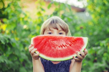Bir çocuk karpuz yiyor. Seçici odak.