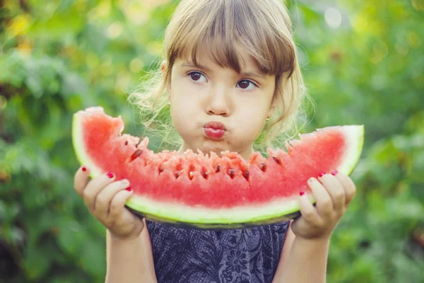 Een kind eet watermeloen. Selectieve aandacht. — Stockfoto