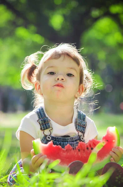 Een kind eet watermeloen. Selectieve aandacht. — Stockfoto