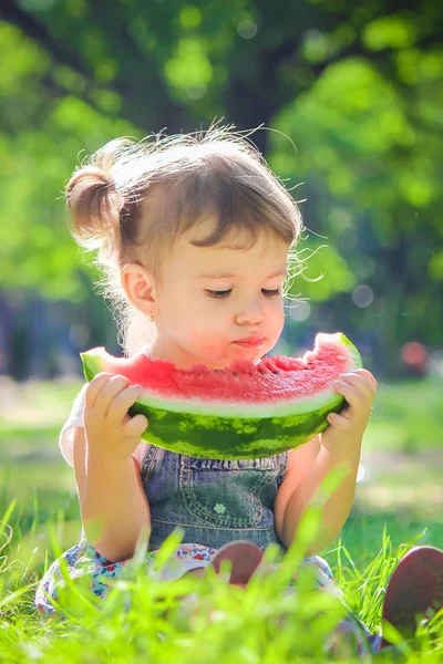 Een kind eet watermeloen. Selectieve aandacht. — Stockfoto