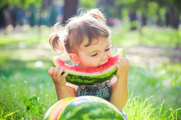 Een kind eet watermeloen. Selectieve aandacht. — Stockfoto