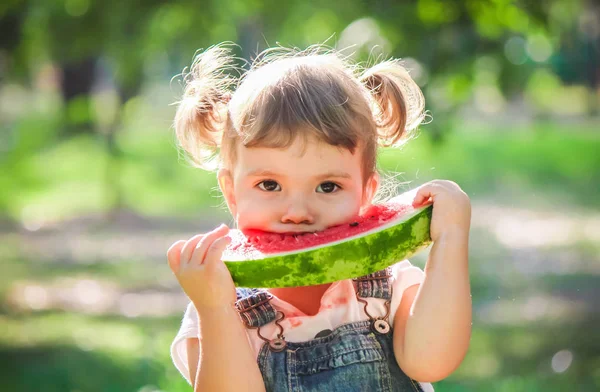 Een kind eet watermeloen. Selectieve aandacht. — Stockfoto