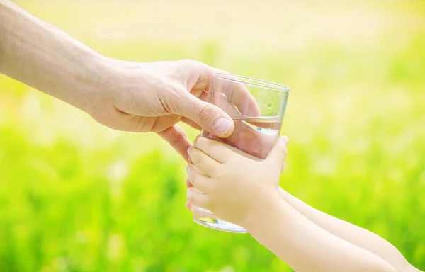 Sang ayah memberi anak segelas air. Fokus selektif . — Stok Foto