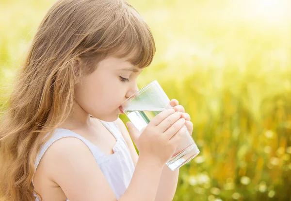 Hält das Kind ein Glas Wasser in der Hand. Selektiver Fokus. — Stockfoto