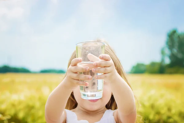 Ребенок держит стакан воды в руках. селективный фокус . — стоковое фото
