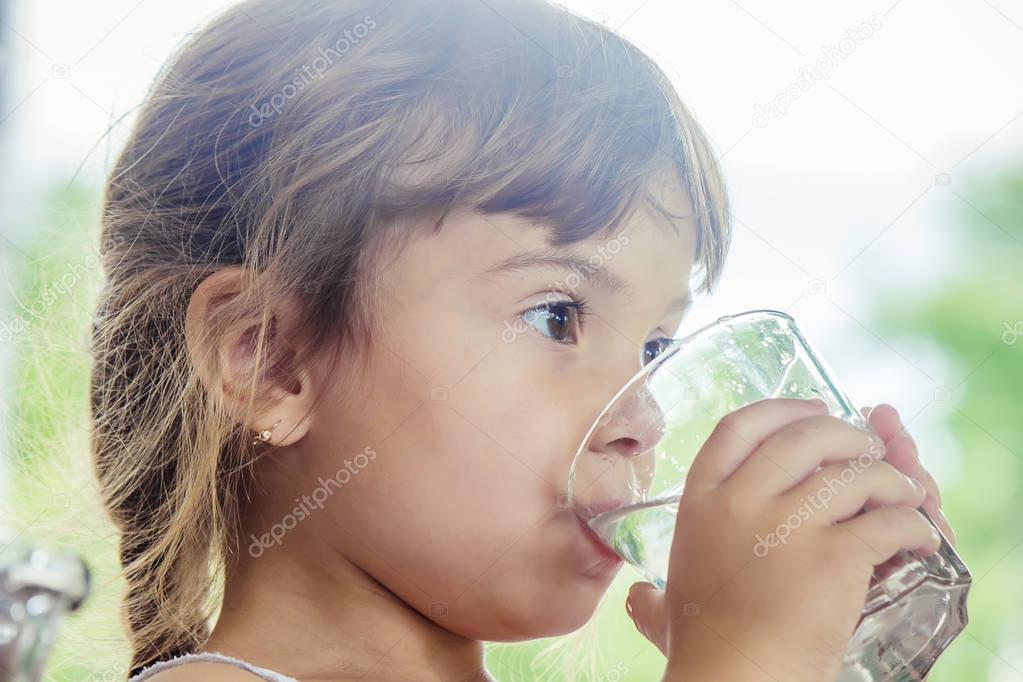 Child pouring and drinking water.