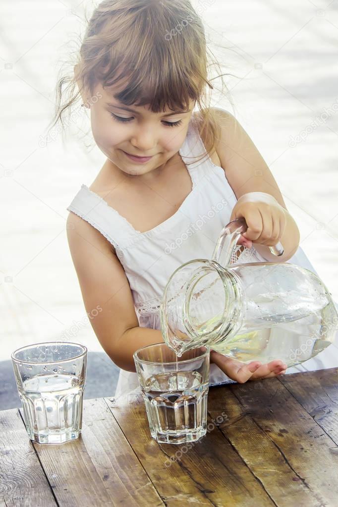 Child pouring and drinking water.