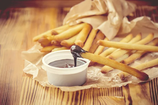 Churros tillagas i ugnen med choklad. Selektivt fokus. — Stockfoto