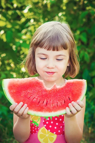 Een kind eet watermeloen. Selectieve aandacht. — Stockfoto