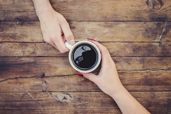 Coffee in hand. The lovers are together. Selective focus.