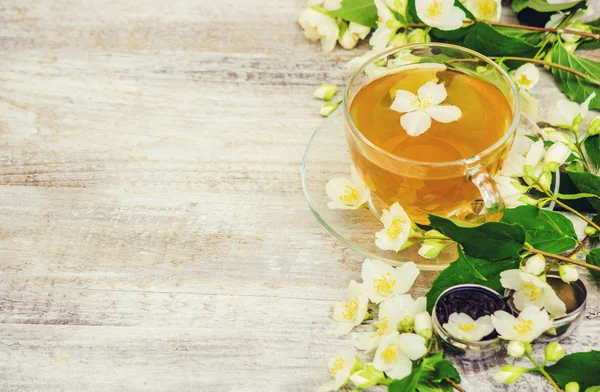 Xícara de chá de ervas com flores de jasmim. foco seletivo . — Fotografia de Stock