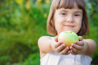 Çocuk bir elma. Seçici odak.
