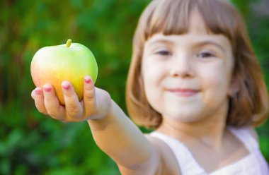Çocuk bir elma. Seçici odak.