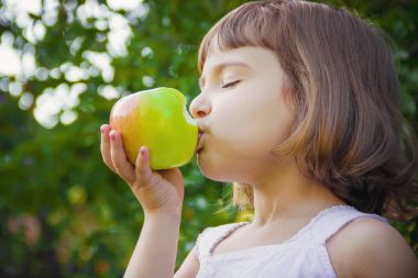 Çocuk bir elma. Seçici odak.