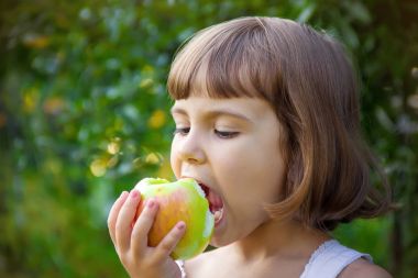 Çocuk bir elma. Seçici odak.