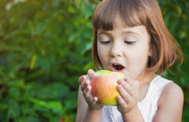Çocuk bir elma. Seçici odak.