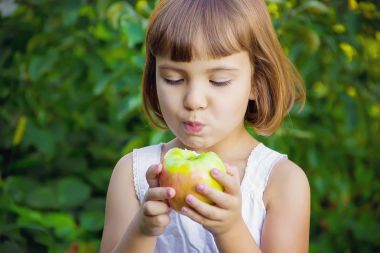 Çocuk bir elma. Seçici odak.
