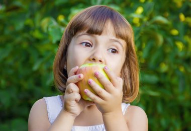 Çocuk bir elma. Seçici odak.