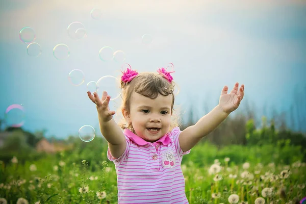 El niño sopla burbujas. Enfoque selectivo . —  Fotos de Stock