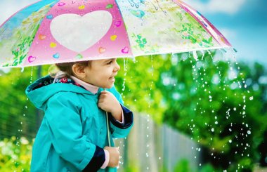 Yağmurda çocuktur. Bir şemsiye ile. Seçici odak. 