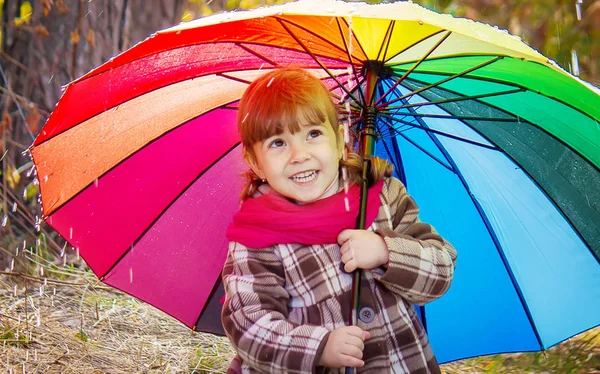 Yağmurda çocuktur. Bir şemsiye ile. Seçici odak. 