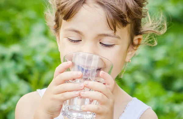 Child drinks water. Selective focus. Stock Picture