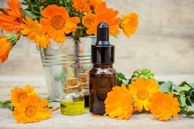 Küçük bir şişe içinde kadife çiçeği özü. Şifalı otlar. Seçici odak. 