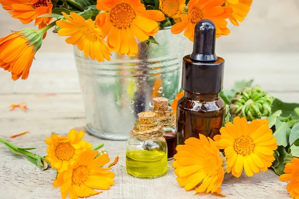 Marigold extract in a small bottle. Medicinal herbs. Selective focus. — Stock Photo, Image