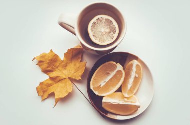 Sonbahar yaprakları ve limon ile çay. Seçici odak.