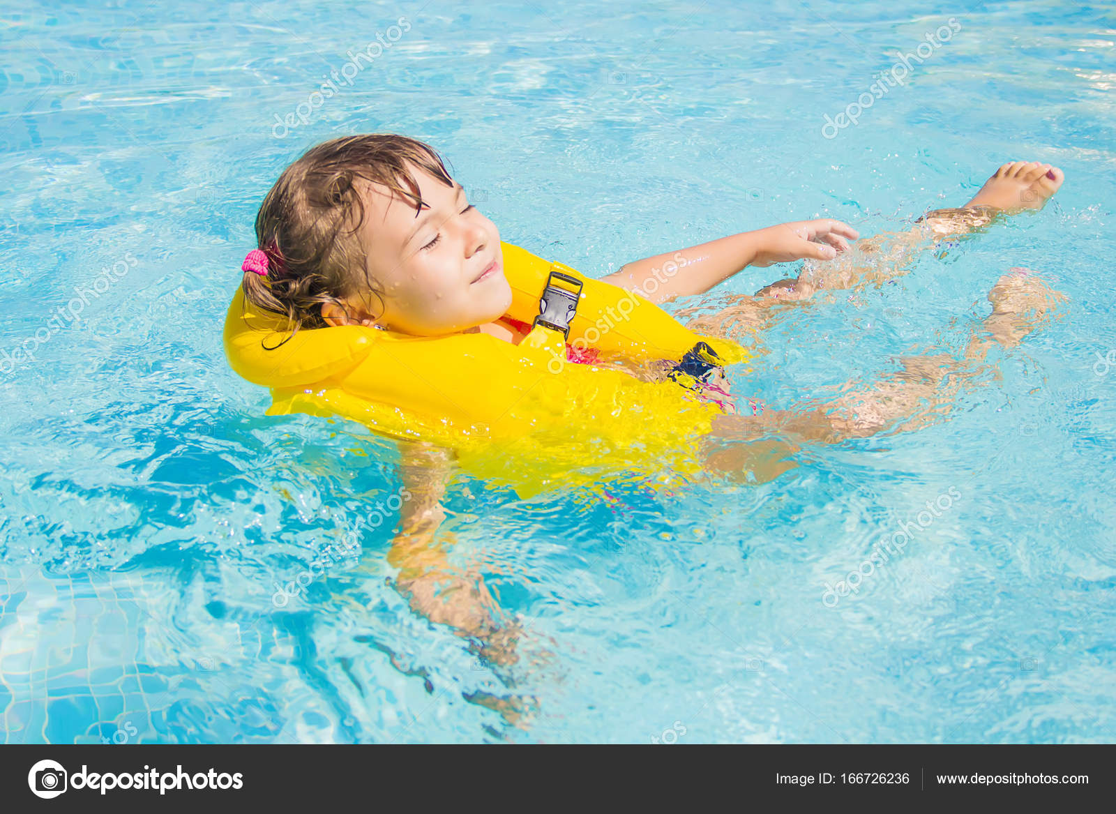 The child is bathing in the pool at the resort. Selective focus