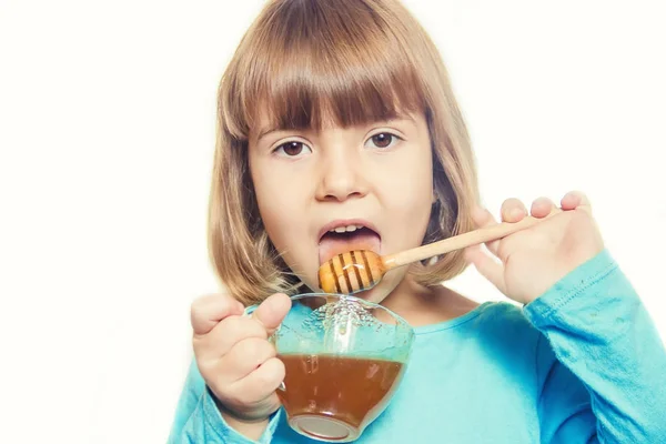 Het kind eet honing. Selectieve focus. — Stockfoto