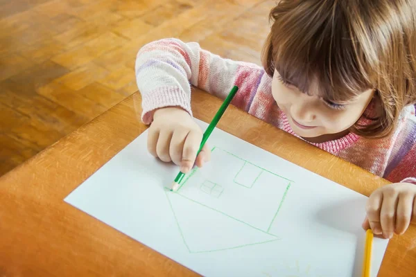 Ein Kind zeichnet ein Haus. Selektiver Fokus. — Stockfoto