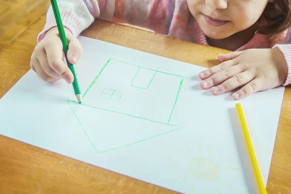 Ein Kind zeichnet ein Haus. Selektiver Fokus. — Stockfoto
